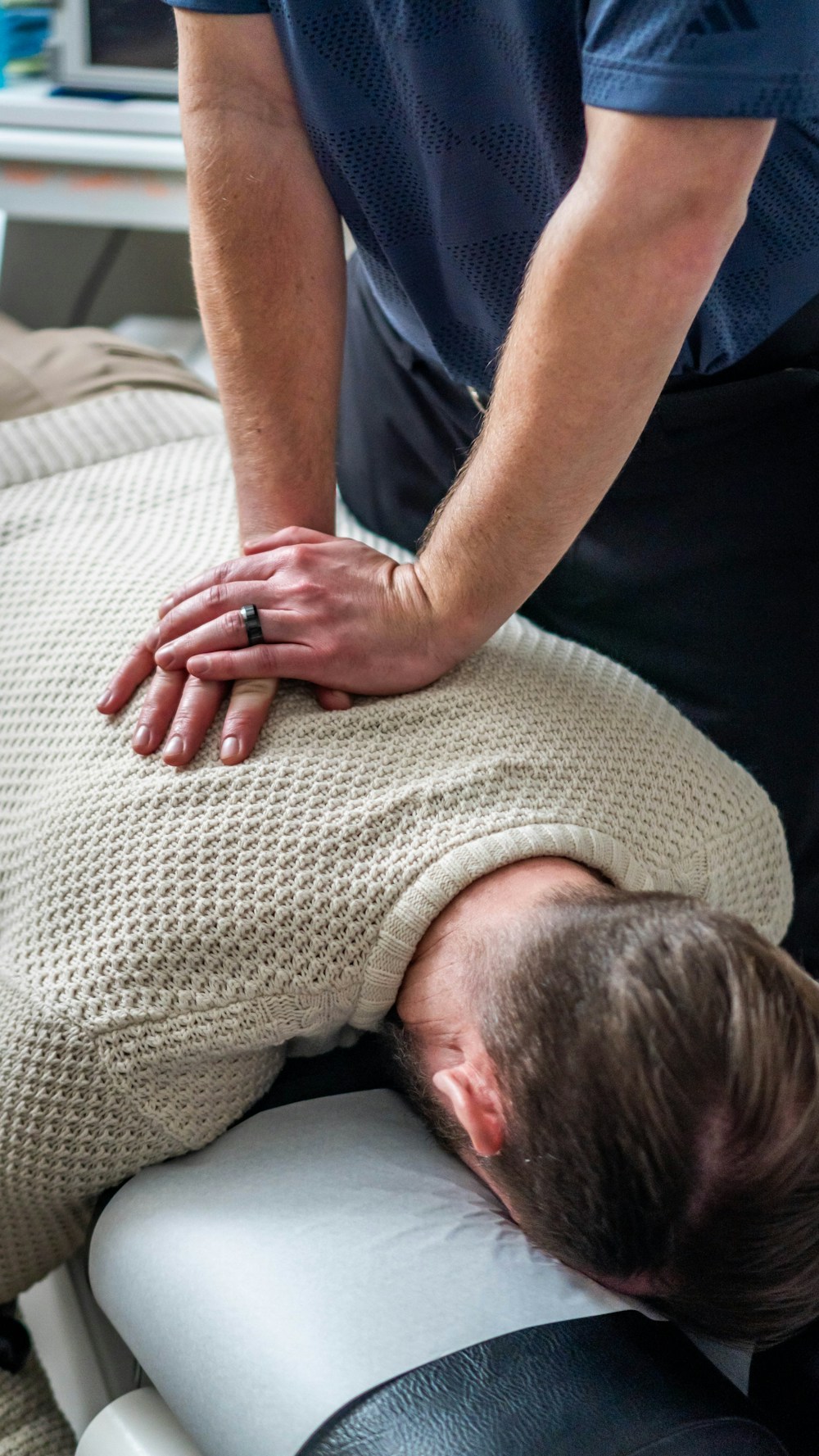 Fisioterapeuta aplicando terapia manual en la espalda alta de un paciente
